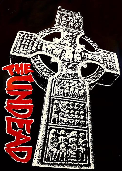 A detailed stone cross with carvings of human figures is depicted against a dark background. The red, stylized text "THE UNDEAD" is prominently displayed on the left side of the cross. This MUS 020: The Undead rock poster is printed on premium 150gsm gloss paper, perfect for any music collection.
