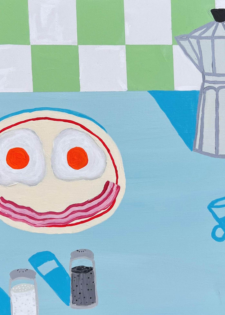 A playful, abstract painting features a smiling face made from food, with fried eggs for eyes and strips of bacon for a mouth, set on a blue table near a moka pot, salt and pepper shakers, and a checkered green wall.