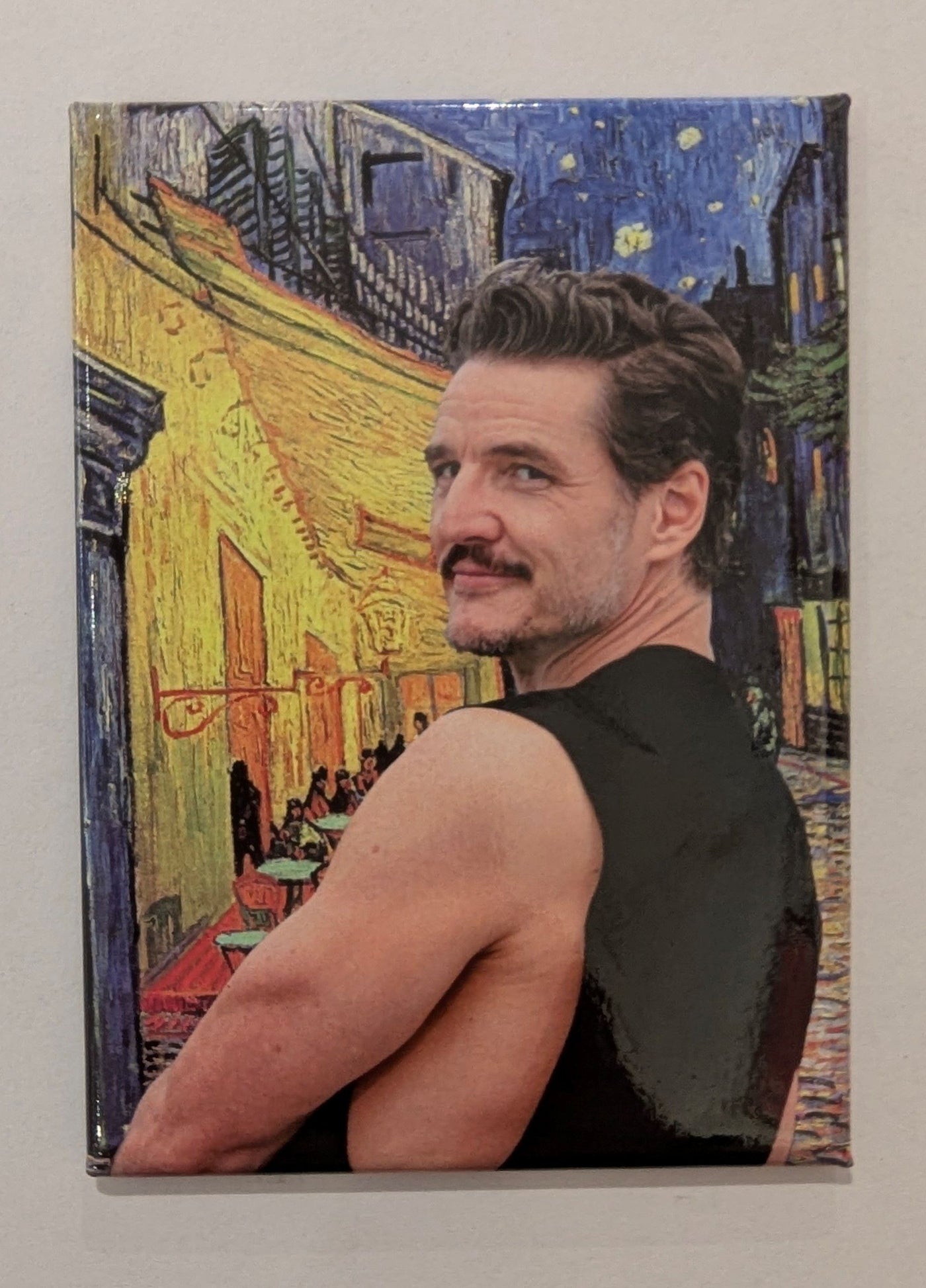 A person with short brown hair, a mustache, and a sleeveless black shirt poses before Van Gogh’s "Cafe Terrace at Night" on the Pedro Van Gogh Cafe Terrace Magnet by Blue Dog Posters—a quirky, sarcastic rectangular magnet for decorating your fridge.