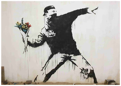A high quality **Banksy Flower Bomber** by **Y** depicts a person dressed in black with a face covering, positioned as if about to throw an object. Instead of a weapon, they are holding a colorful bouquet of flowers. The artwork is printed on 250gsm Satin Paper, combining stark black and white with vivid colors.