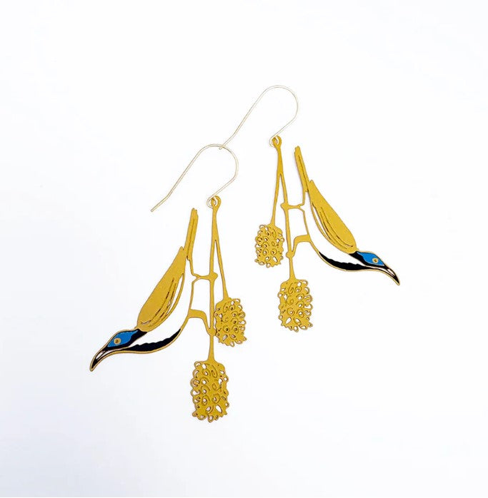 Blue Faced Honeyeater by Denz earrings from Blue Dog Posters feature bird shapes perched on branches with delicate flowers. Their blue and black accents stand out atop lightweight, hypoallergenic materials against a white background.