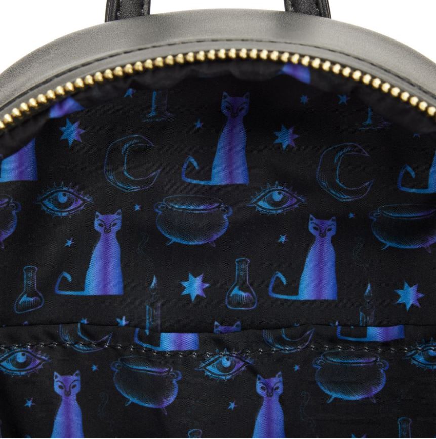 A close-up of the inside of the Hocus Pocus Binx Plush Pocket Mini Backpack by Blue Dog Posters reveals a vibrant, enchanting lining. The mystical pattern features blue and purple cats, crescent moons, stars, potion bottles, cauldrons, eyes, and a small tower set against a dark backdrop—a design that is sure to captivate fans of Hocus Pocus.