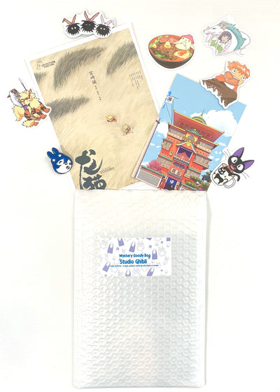 The “Mystery Goodie Bag - Studio Ghibli” by Blue Dog Posters features a Totoro notebook, postcards, an enamel pin, and assorted Studio Ghibli character stickers—perfect for fans of the beloved films.