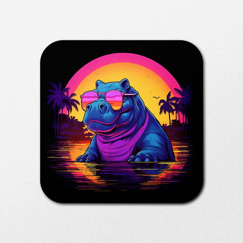 The Flouro Hippo Coaster from Blue Dog Posters showcases a blue hippo in pink sunglasses sitting in water, surrounded by a vibrant sunset with palm trees. The orange and pink sky reflects on the water, creating a tropical ambiance.
