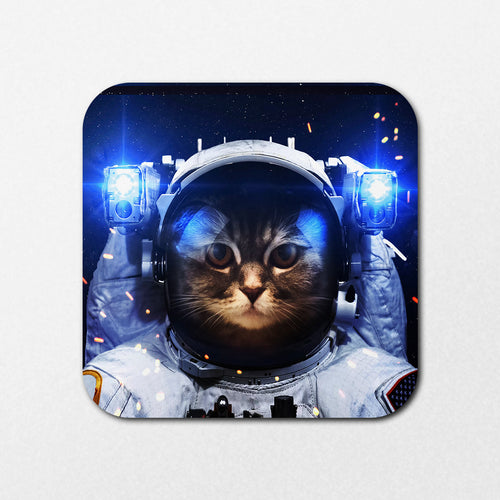 The Space Cat Coaster by Blue Dog Posters features a cat in an astronaut suit and space helmet, floating in a starry sky. The blue-lit helmet and surrounding sparks create a dynamic sci-fi vibe.