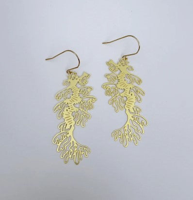 Leafy Sea Dragons Earrings by Denz from Blue Dog Posters—gold earrings with intricate, organic designs inspired by leafy sea dragons, shown against a plain white background.