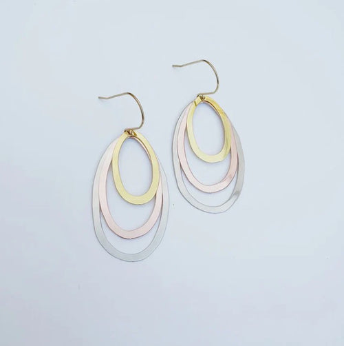 The Midi Triple Oval Earrings Mixed Metals by Denz from Blue Dog Posters feature three overlapping ovals in gold, rose gold, and silver tones, crafted from recycled stainless steel and shown on a plain white background.