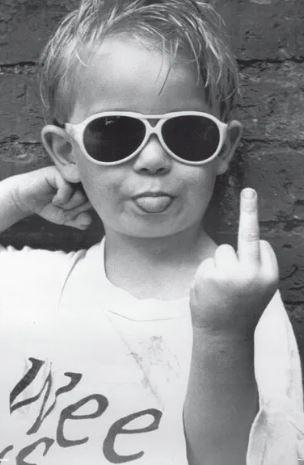 A young child in sunglasses sticks out their tongue and raises their middle finger against a brick wall—featured in "Hi Mum," a bold Large Regular Poster from ALT 040's Life & Humour Collection.