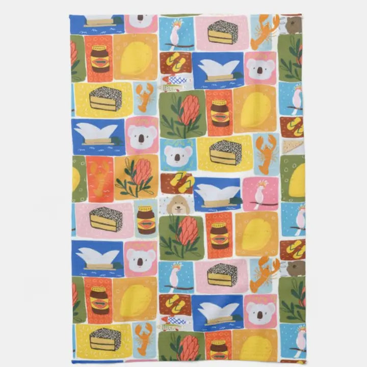 Bright Aussie Icons Kitchen Tea Towel by Blue Dog Posters, featuring koalas, native flowers, lamington cakes, lobsters, and swans in a colorful patchwork design. Melbourne designed.
