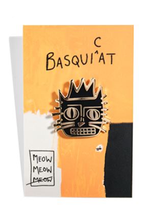 The Basquicat Enamel Pin by Blue Dog Posters, showcasing a stylized cat face with a crown in black and gold enamel, is displayed against an asymmetrical orange, white, and black background. At the top, the word "BASQUIAT" appears in black with an unfinished "C" preceding it and the phrase "MEOW MEOW MEOW" is placed in the bottom left corner.