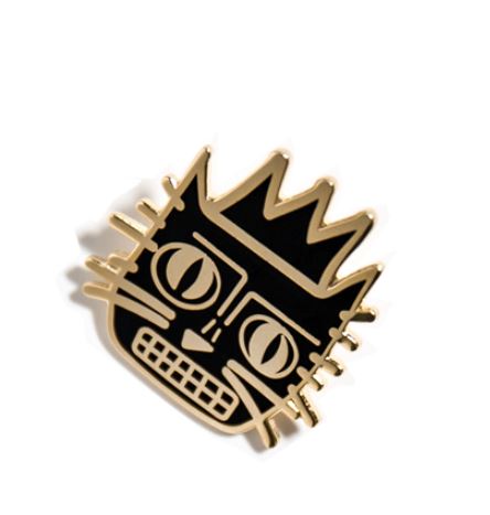 A Blue Dog Posters Basquicat Enamel Pin featuring an abstract, stylized black and gold face with a crown. The design includes geometric shapes for the eyes, nose, and mouth, with exaggerated lines for facial features and a crown placed on top, reminiscent of contemporary art styles.