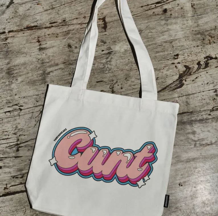 The CUNT Tote Bag Natural by Blue Dog Posters is a premium cotton canvas tote featuring "Cunt" in bold pink and blue bubble letters on a textured, weathered background.