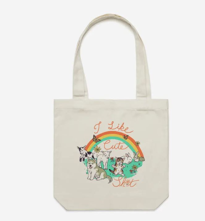 The Cuteness Tote Bag Natural by Blue Dog Posters is a beige cotton canvas tote with six cute cats, a rainbow, flowers, and "I Like Cute Shit" in cursive—ideal for carrying your essentials with playful charm.