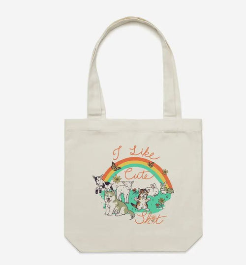 The Cuteness Tote Bag Natural by Blue Dog Posters is a beige cotton canvas tote with six cute cats, a rainbow, flowers, and "I Like Cute Shit" in cursive—ideal for carrying your essentials with playful charm.