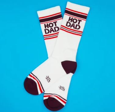 Hot Dad Gym Crew Socks by Blue Dog Posters feature red and black stripes with "HOT DAD" near the top, plus dark toes and heels. Displayed on a blue background, they're perfect for self-care or lawn mowing.