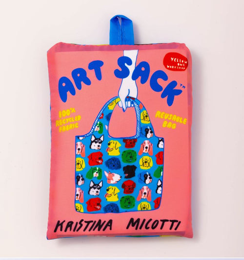 A folded reusable bag with a pink background is labeled "ART SACK" and features a colorful illustration of a bag covered in cartoon animal faces. The text reads "100% Recycled rPet" and "Kristina Micotti." An Eco-friendly Dogs Art Sack from Blue Dog Posters, it has a blue tag at the top.