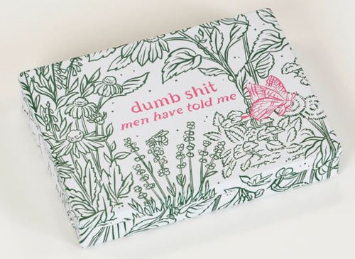 The Dumb Shit Small Tin by Blue Dog Posters features a white background, green floral designs, pink "dumb shit men have told me" text, and a pink butterfly—perfect compact storage for keepsakes or notes.
