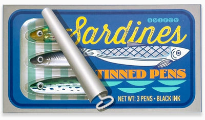 A novelty set of three pens, designed to resemble sardines in a tin. The packaging reads, "Tinned Fish Pens" under the Blue Dog Posters brand, featuring fish and water illustrations. The tin's lid is slightly rolled back to reveal the sardine-shaped pens.