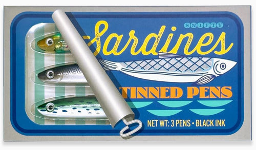 A novelty set of three pens, designed to resemble sardines in a tin. The packaging reads, "Tinned Fish Pens" under the Blue Dog Posters brand, featuring fish and water illustrations. The tin's lid is slightly rolled back to reveal the sardine-shaped pens.