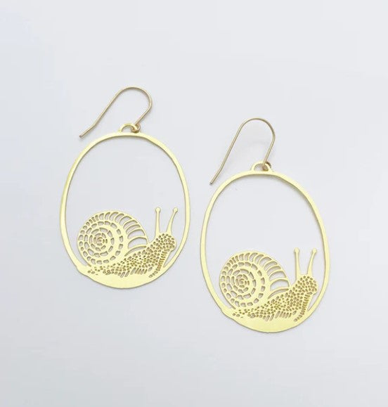 A pair of Snails in Gold Dangle Earrings by Blue Dog Posters showcases a whimsical design of slippery snails elegantly encased in oval frames against a plain white backdrop.