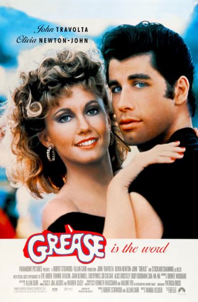 A Large Regular Poster for MTV 099’s “Grease,” showing a smiling blonde woman and a man with dark slicked-back hair embracing, actor names at the top, and "Grease" boldly displayed below.