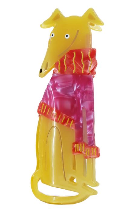 The Grey Hound in a Jumper Hair Claw by Blue Dog Posters is a colorful, stylized dog figurine crafted from yellow and pink plant-based acetate, featuring a long snout, pointed ears, and a red scarf with yellow stripes.