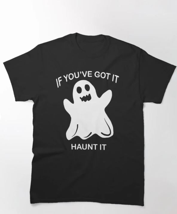 The Blue Dog Posters "Ghost Haunt It T-shirt Black LGE" features a centered design of a simple cartoon ghost with a happy, open-mouthed expression. Above and below the ghost are the white, uppercase words "IF YOU’VE GOT IT HAUNT IT.