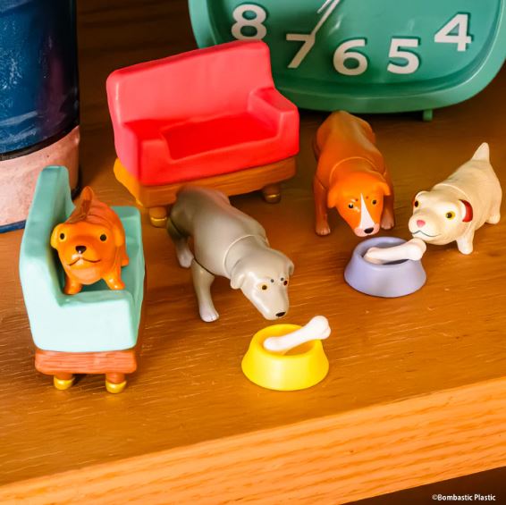 The Hello in the World Vol 7 Neil Ewing Blind Box by Blue Dog Posters features four collectible mini toy dogs with two colorful couches, dog bowls with bones, and a green clock—ideal for collectors and dog lovers.