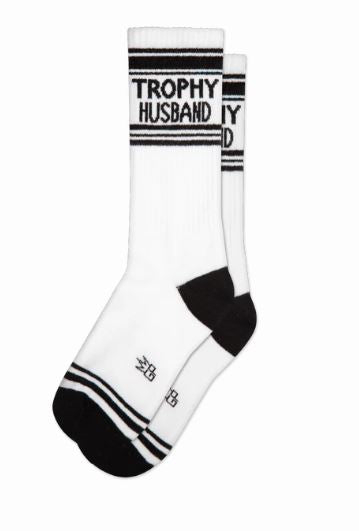 Trophy Husband Gym Crew Socks by Blue Dog Posters: white unisex socks with black toes, heels, stripes, and "TROPHY HUSBAND" in bold black letters near the top.