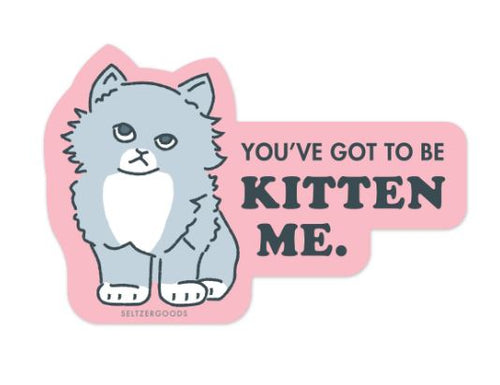 The Kitten Me Vinyl Single Sticker by Blue Dog Posters features a cute gray cat with a white chest and "You've got to be kitten me" in bold on pink—perfectly water-resistant for laptops!.
