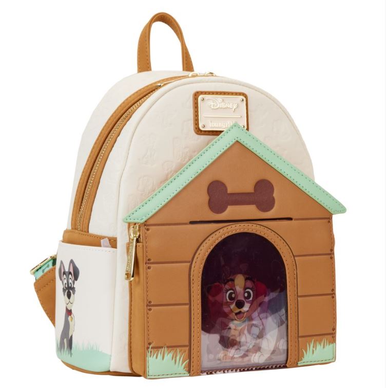 The Disney I Heart Dogs Mini Backpack by Blue Dog Posters is a tan and white backpack designed with a charming doghouse theme. The front of the bag mimics a doghouse, showcasing an animated dog's face peeking through a clear window. It features green grass details and triple lenticular effects on the cartoon dog illustration on the side.