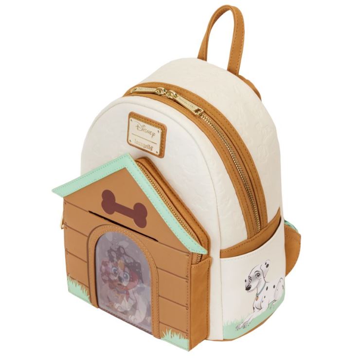 This mini backpack, called the Disney I Heart Dogs Mini Backpack by Blue Dog Posters, showcases a delightful Dalmatian design. It features a small house on the front pocket with a Dalmatian puppy peeking through a mesh doorway. The backpack has a white base with brown accents and displays the Disney logo and text on a leather patch at the front.