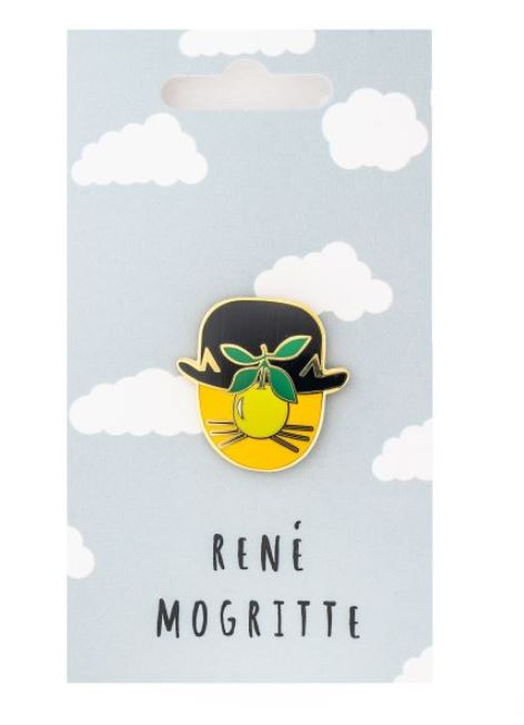 A Rene Mogritte Enamel Pin by Blue Dog Posters featuring a stylized representation of René Magritte's "The Son of Man." It depicts a figure in a bowler hat with a green apple obscuring the face, set against a background of clouds. The text "René Magritte" appears below the pin.