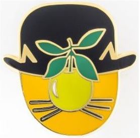 A stylized illustration of a face with a yellow and black color scheme, partly obscured by a green pear with leaves. The face is topped with a black bowler hat, and a black mustache is visible below the pear. The background is white. This captivating design is featured on the Rene Mogritte Enamel Pin by Blue Dog Posters.