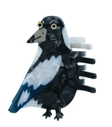 The Magpie Hair Claw from Blue Dog Posters features a glossy, marbled black-and-white magpie with blue wing accents and yellow eyes—perfect for adding charm to messy buns or channeling Bea Bellingham’s signature style.