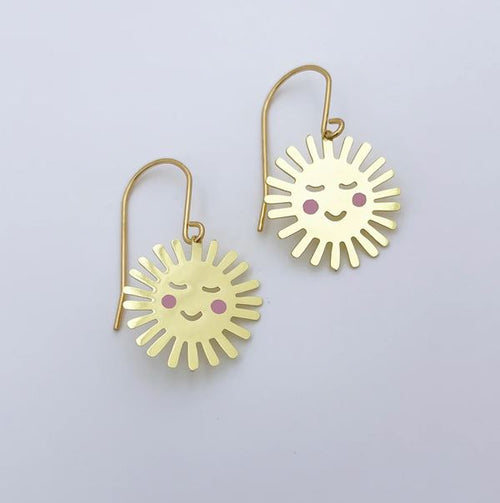 The Mini Cheeky Sun Earrings Gold by Denz from Blue Dog Posters feature smiling suns with closed eyes and pink cheeks, shown against a plain white background.