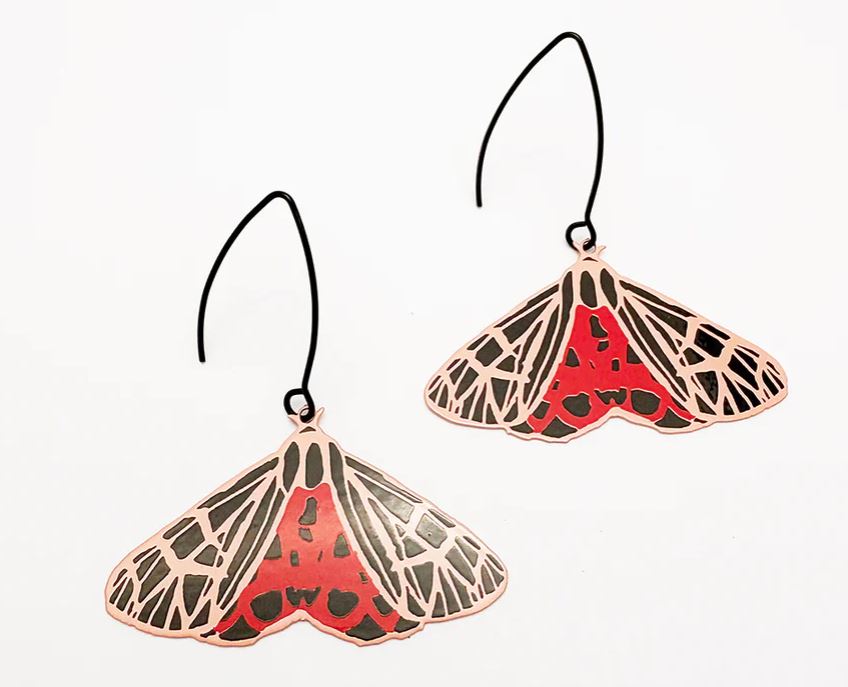 Moth Ornate Tiger Earrings by Denz from Blue Dog Posters, shaped like moths with black, cream, and red wing patterns and long black hooks. Hypoallergenic earrings shown on a white background.