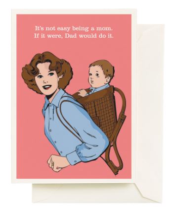 The Not Easy Mother's Day Card by Blue Dog Posters features a smiling woman carrying a baby in a backpack carrier on a pink background. The card reads, "It's not easy being a mom. If it were, Dad would do it." Includes white recycled paper envelope.