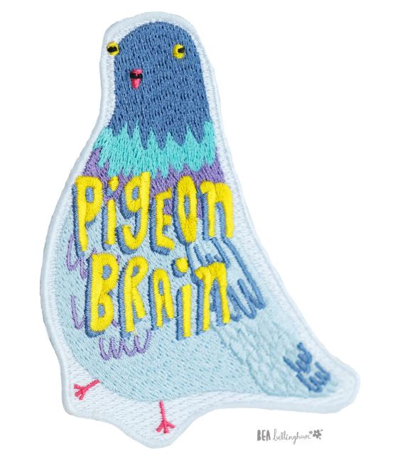 The Pigeon Brain Patch by Blue Dog Posters is a vibrant iron-on patch with blue, teal, and purple feathers, a red beak, black eyes, and "Pigeon Brain" boldly stitched in yellow for a quirky style statement.