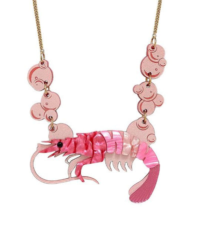 Discover the Pearly Prawn Necklace Pink by Blue Dog Posters, a playful and vibrant piece crafted by a renowned UK Jewellery Designer. The pendant is intricately shaped like a shrimp, made of pink acrylic with iridescent highlights, and it dangles from a gold chain adorned with circular pink embellishments.