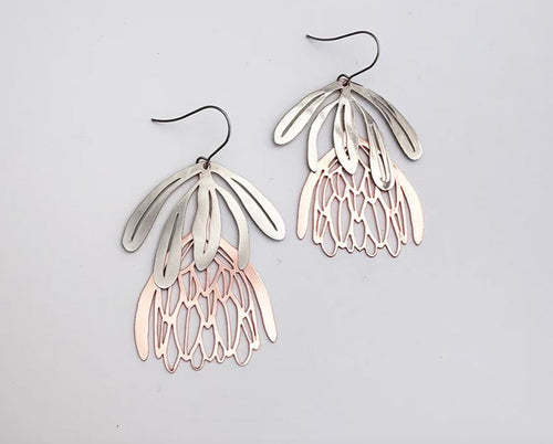 The Protea Flower Silver Rose Gold Denz Earrings from Blue Dog Posters are lightweight dangles with silver elongated ovals on top and layered rose gold petals below, inspired by protea flower shapes.