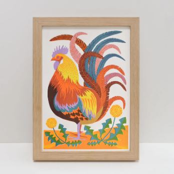 The Rooster A4 Risograph by Vicki Johnson from Blue Dog Posters features a vibrant rooster on orange ground with green leaves and yellow flowers, printed with eco-friendly soy-based inks.