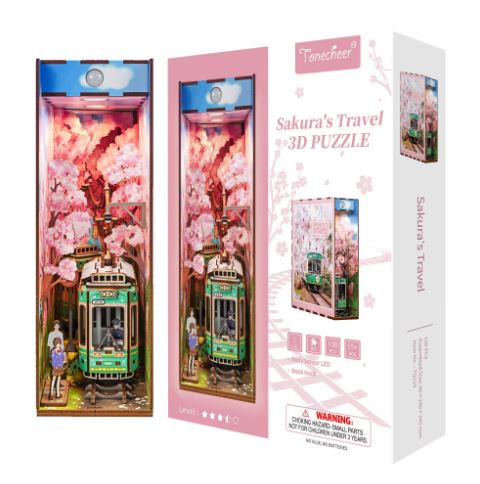 The Sakura's Travel Book Nook Tonecheer by Blue Dog Posters is a 3D puzzle featuring a green tram, cherry blossoms, and figures set against a pink Kyoto-inspired scene—an ideal Japan DIY bookshelf insert.