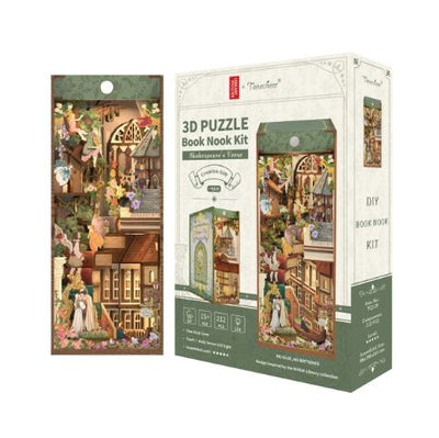 The Shakespears' Verse Large Book Nook by Blue Dog Posters is a 3D puzzle kit featuring a detailed Shakespearean love scene with figures, buildings, and greenery. The box shows the finished design and includes assembly instructions.