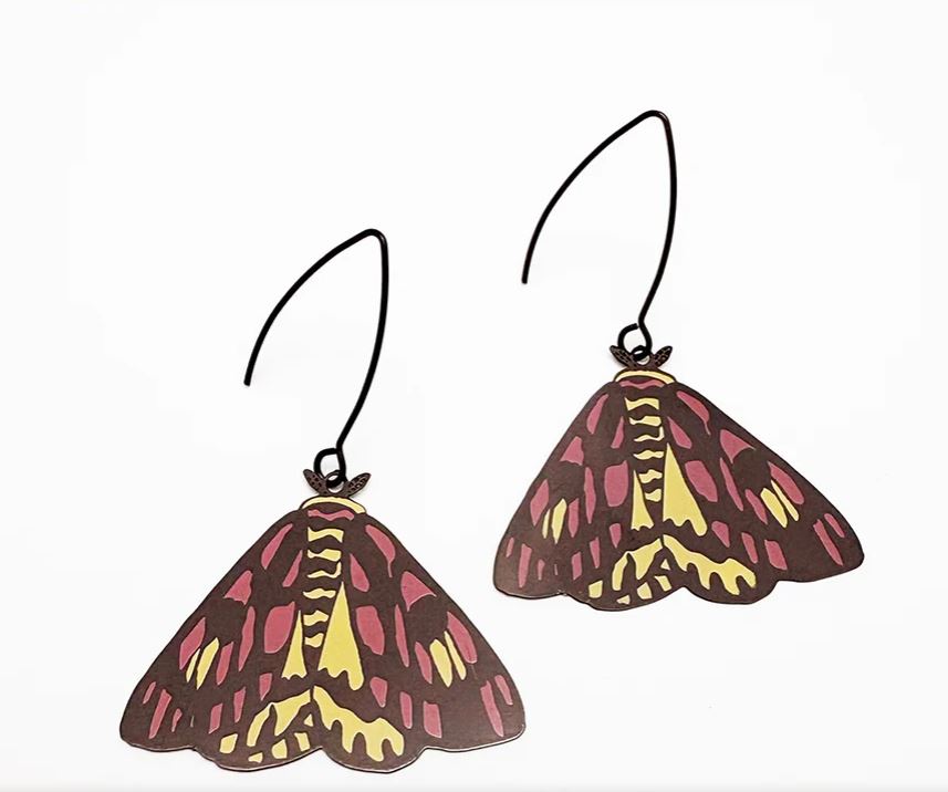 Moth Sheep Moth Earrings by Denz from Blue Dog Posters—yellow, pink, and dark brown moth shapes on black hooks, displayed on white. Made from recycled stainless steel for hypoallergenic comfort.
