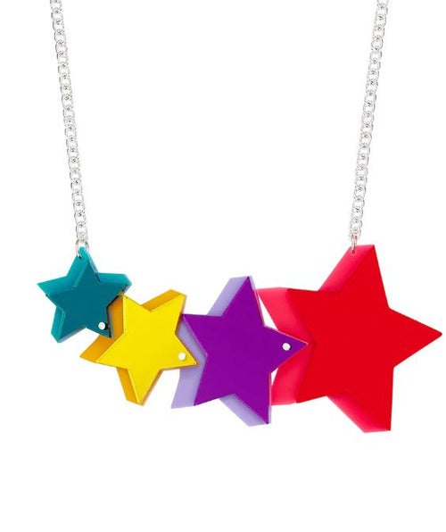 Introducing the Pop Stars Necklace by Blue Dog Posters: a statement necklace featuring colorful, star-shaped pendants on a silver chain. From left to right, it showcases a small teal star, a medium yellow star, a medium purple star, and a large red star—each overlapping in vibrant harmony.