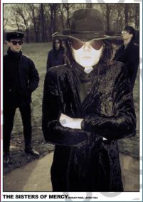 Four people stand outdoors; the front figure sports a black hat, sunglasses, and coat with crossed arms, exuding hip hop energy. Others in dark clothing stand behind among trees—ideal for a bold MUS 155 "Sisters of Mercy - Leeds 1984" poster.
