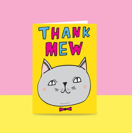 The Thank Mew Greeting Card by Blue Dog Posters is crafted from quality materials and showcases a playful cartoon cat's face adorned with a tiny bow tie. The design features a vibrant yellow background that transitions into a pink two-tone style, with the words "THANK MEW" boldly displayed above the cat in colorful letters. This charming card makes an excellent addition to any giftware collection.