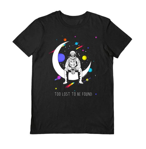 The Blue Dog Posters "Darker Days Too Lost Black T-Shirt Medium" showcases an artistically designed astronaut on a crescent moon with colorful planets and stars, with the phrase "Too Lost to Be Found," highlighting our commitment to supporting artists.