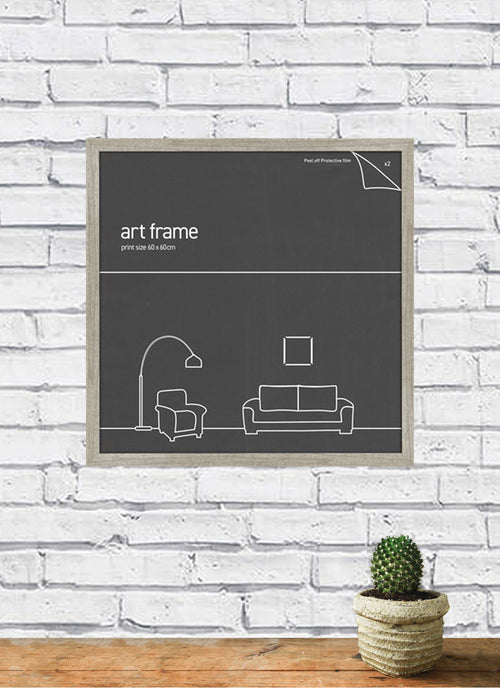 A Classic Frame 60x60cm Ash by Blue Dog Posters, featuring a minimalist line drawing of a living room setup with a floor lamp, armchair, couch, and picture, is mounted on a white brick wall. Part of our Large Frames Collection for 60cm x 60cm posters. Below the frame sits a small cactus in a pot on a wooden surface.
